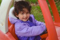 preschool girl driving a play car outside