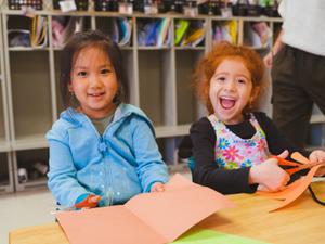 two kinder girls doing paper crafts