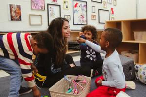 educator and preschoolers playing with doctor toys