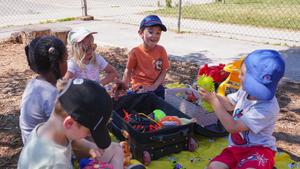 kinders playing outside with toys