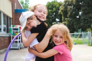 three kinder girls hugging