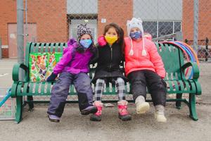 three school age girls on a bench