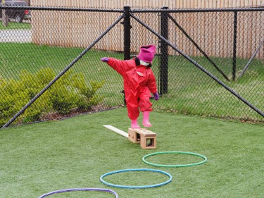 preschooler balancing on a wooden brick
