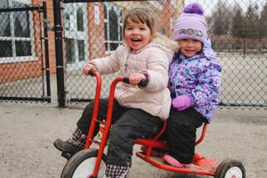 two preschooler girls on a bike