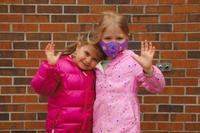 two kinder girls waving