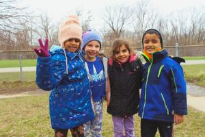 school age children smiling together outside