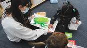 child and teacher reading a picture book