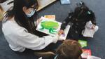 child and teacher reading a picture book