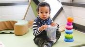 infant playing with stacking toys