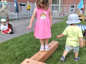 preschool girl balancing on a board
