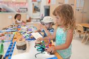 3 preschoolers playing with loose parts