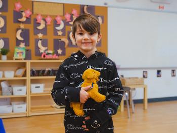 little boy holding a stuffed dog toy