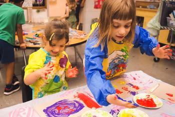 two kinder girls painting with their hands