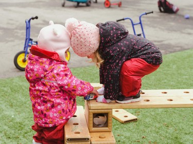 two toddlers helping eachother climb