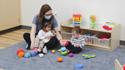 Educator and infants playing with toys.