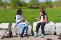 two school age girls chatting over a snack