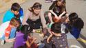 school age children learning how to use a hammer