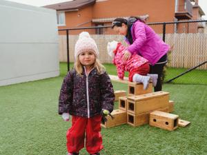 toddlers playing outside with educator
