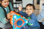 Infant plays with educator