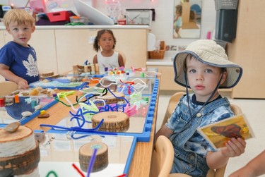 3 preschoolers playing with various loose parts