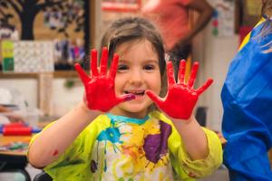 kinder girl with red paint on her hands