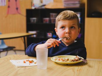 little boy eating kabab lunch