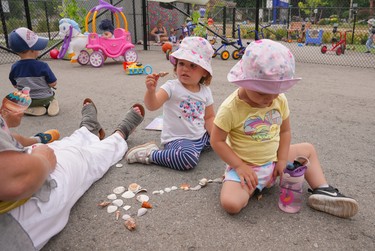 toddlers playing with loose shells outside
