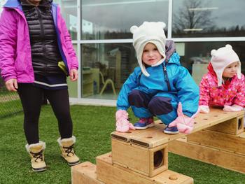 toddler on top of a wooden obstacle