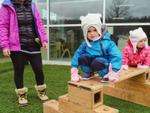 toddler on top of a wooden obstacle