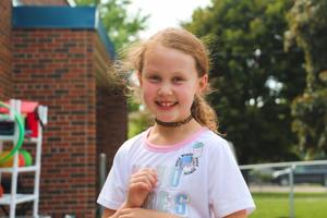school age girl smiling outside