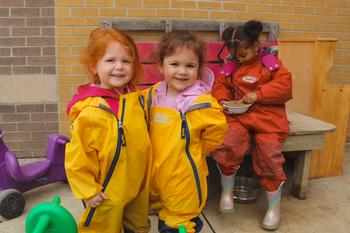 three preschool girls smiling outside
