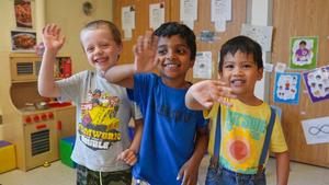 three preschoolers waving