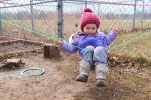 preschool girl climbing ropes outside